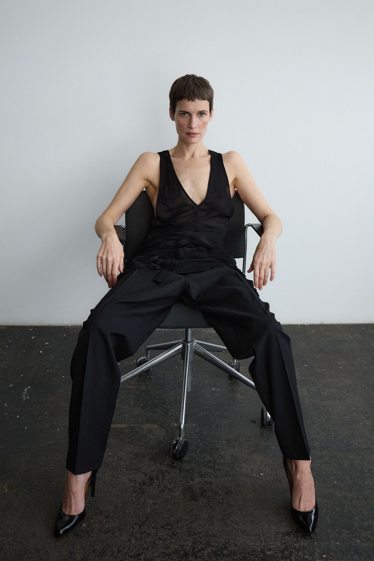 Model wearing black sat on chair