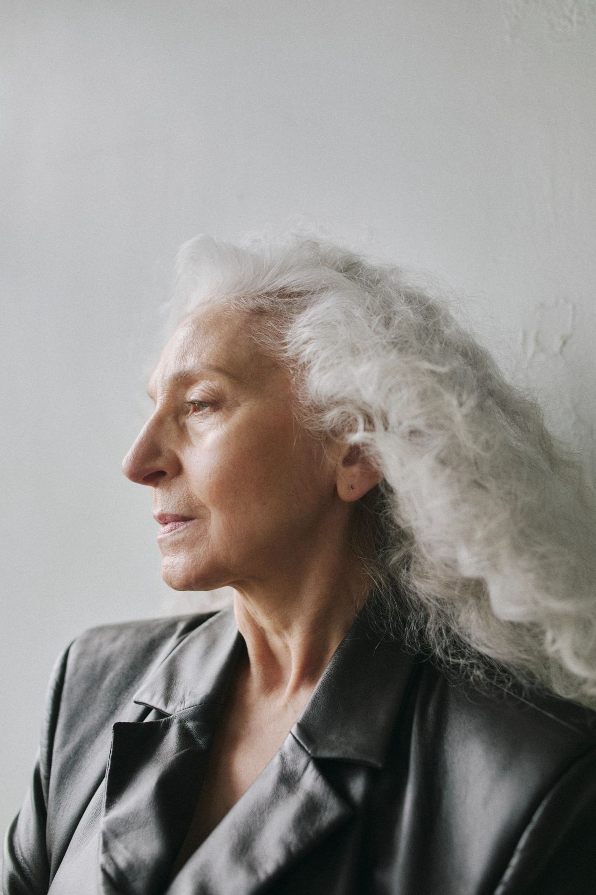 portrait of a Women with grey wavy hair wearing black leather coat