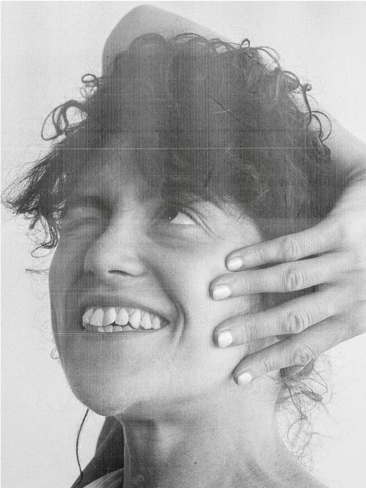 women with a cray smile and hand on face