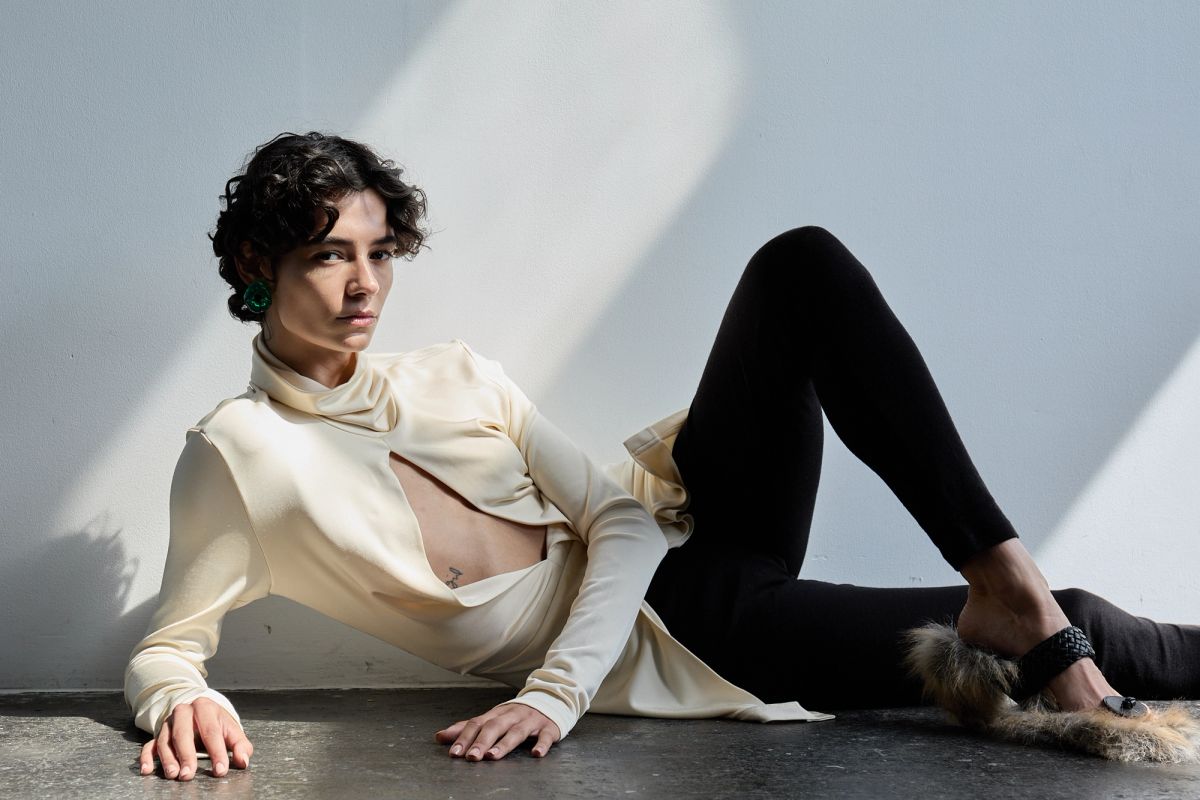 woman lying on the floor in cream top and black leggings