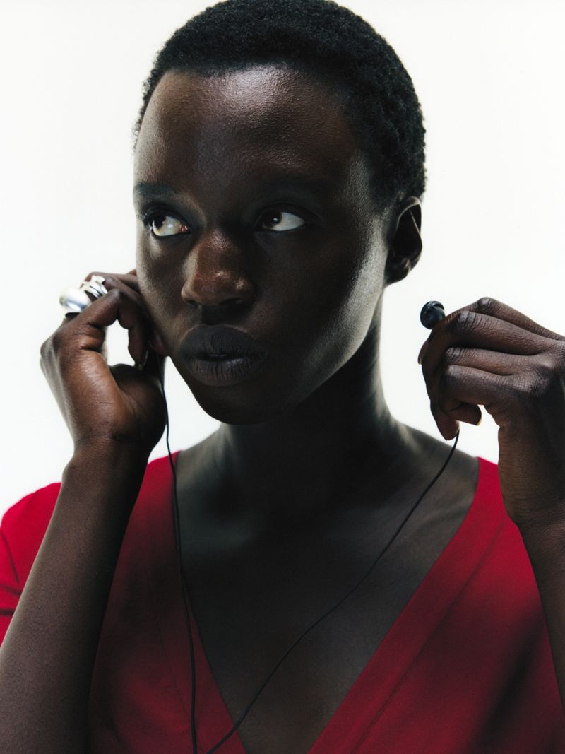 model wearing red pulling out her earphones