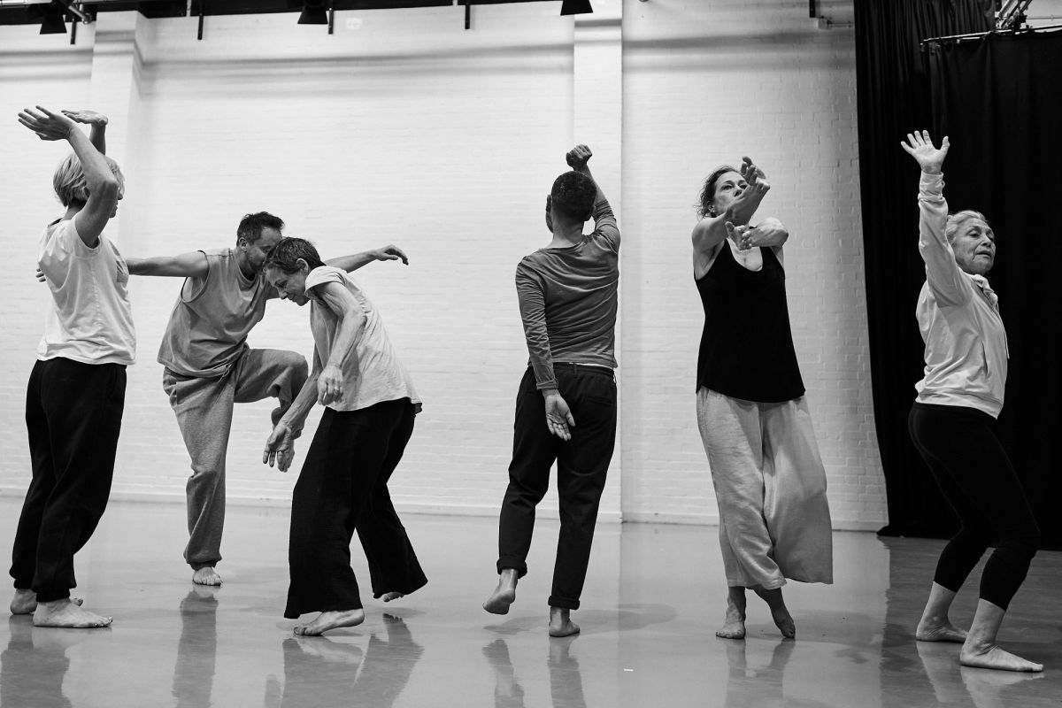A group of dancers using their bodies to move and stretch in a dance studio