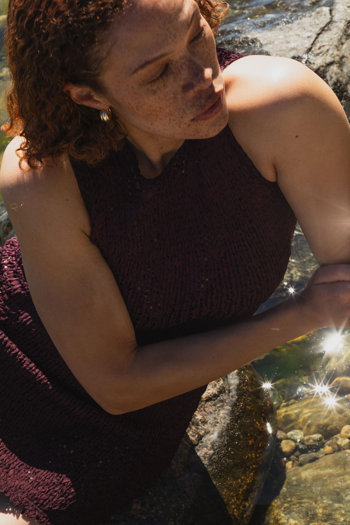 Women sitting in the ocean wearing a dress