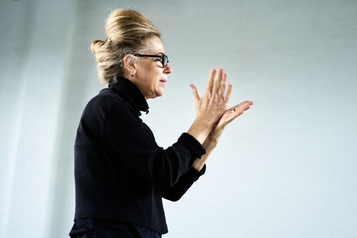 Woman in black turtle neck giving instructions through hand movements
