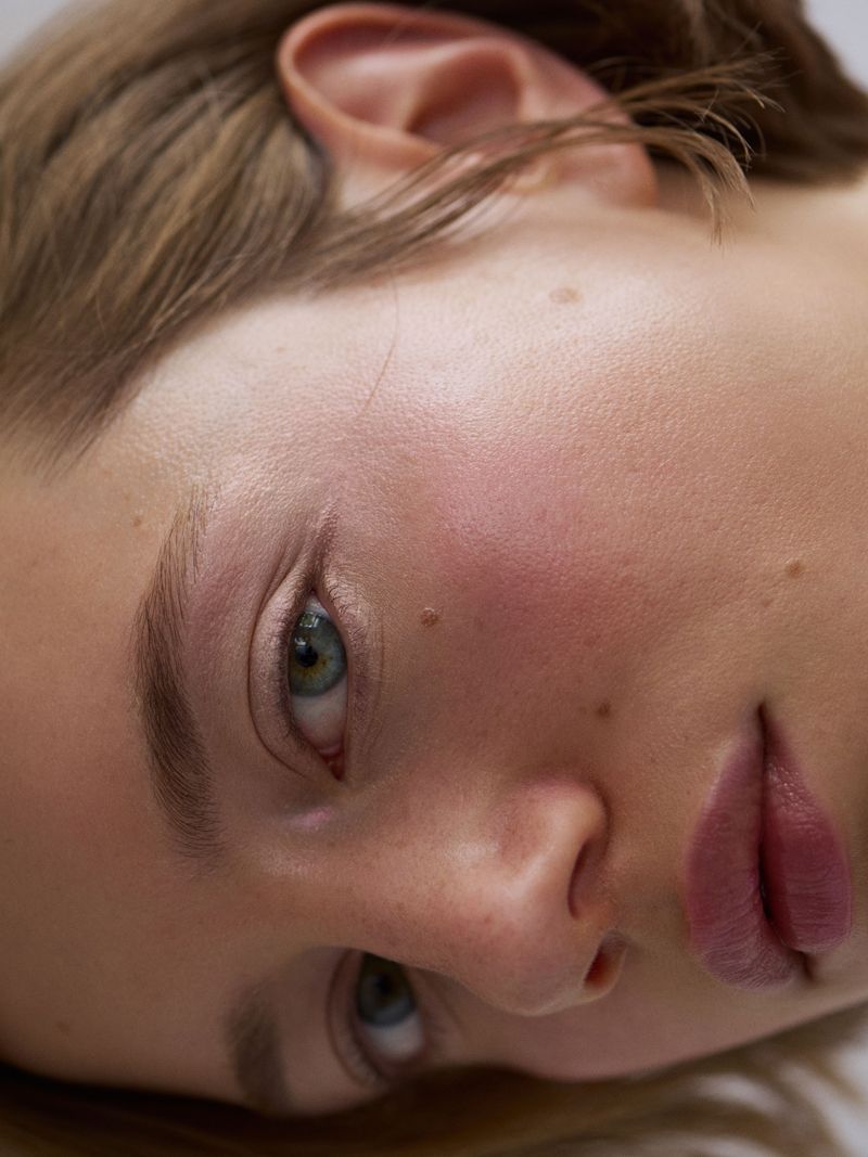 close up of a women with delicate soft blush across her cheeks