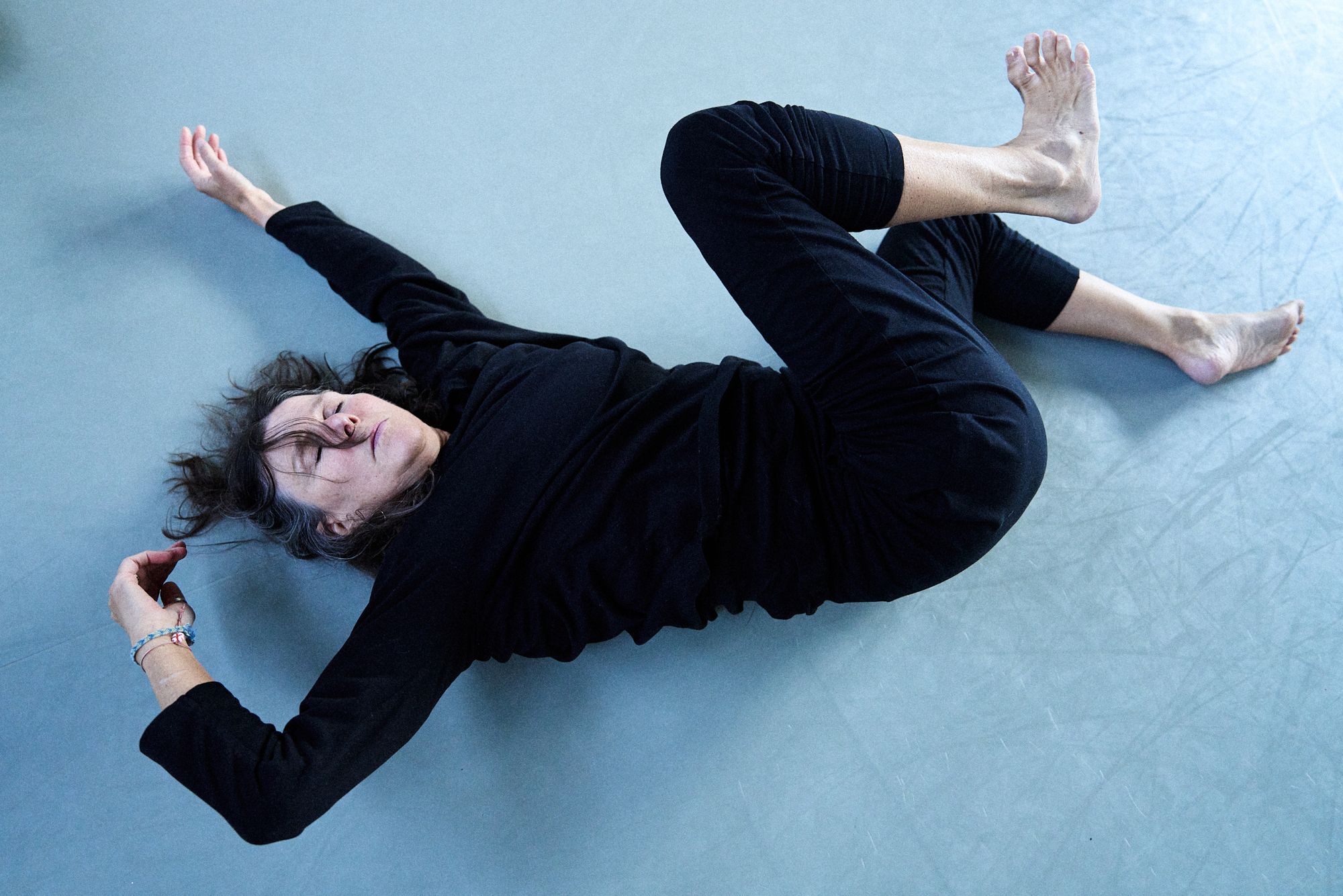 women stertching on a dance studio floor wearing black