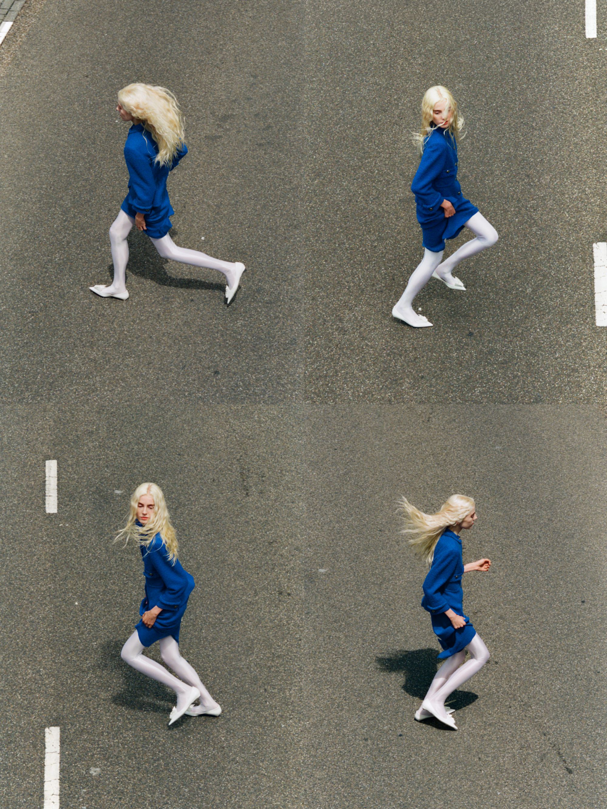 women in blue suit running across a road