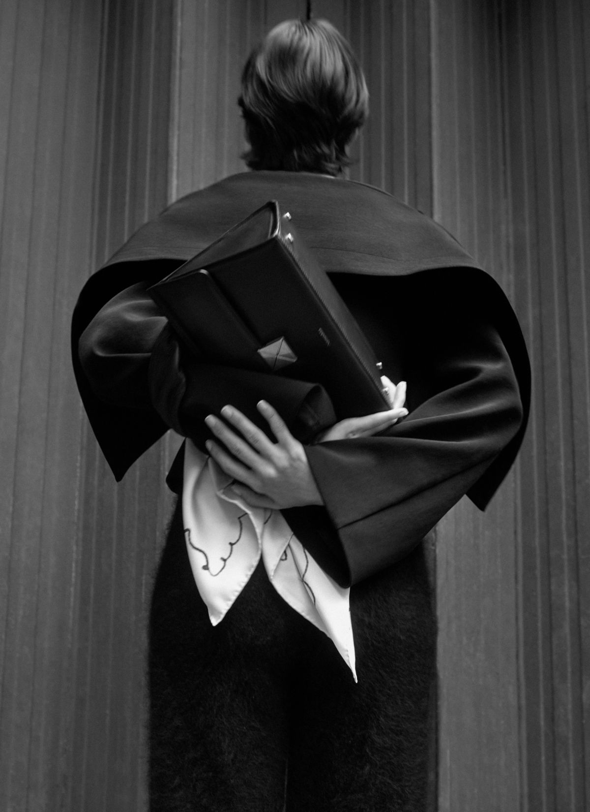 mode with her back to camera holding a bag upsidedown