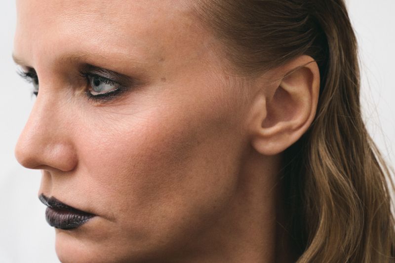 Women with dsmokey eyes and black liftick looking off to the left on a white background