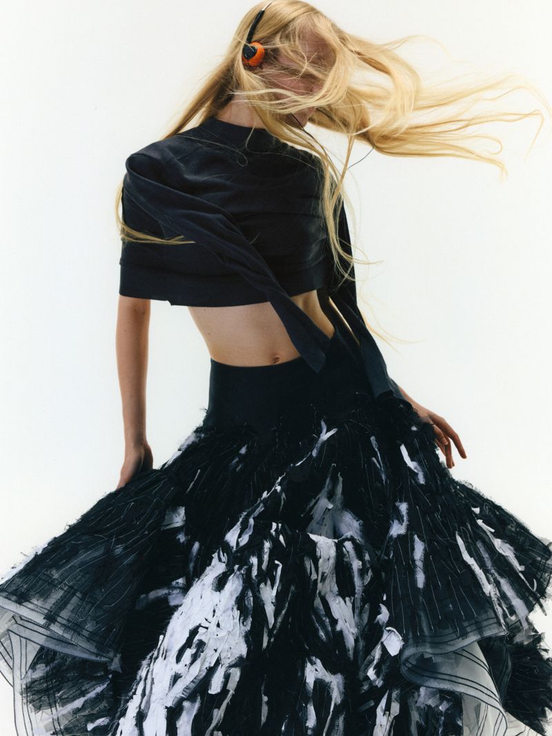 model in black on a white background shaking her hair