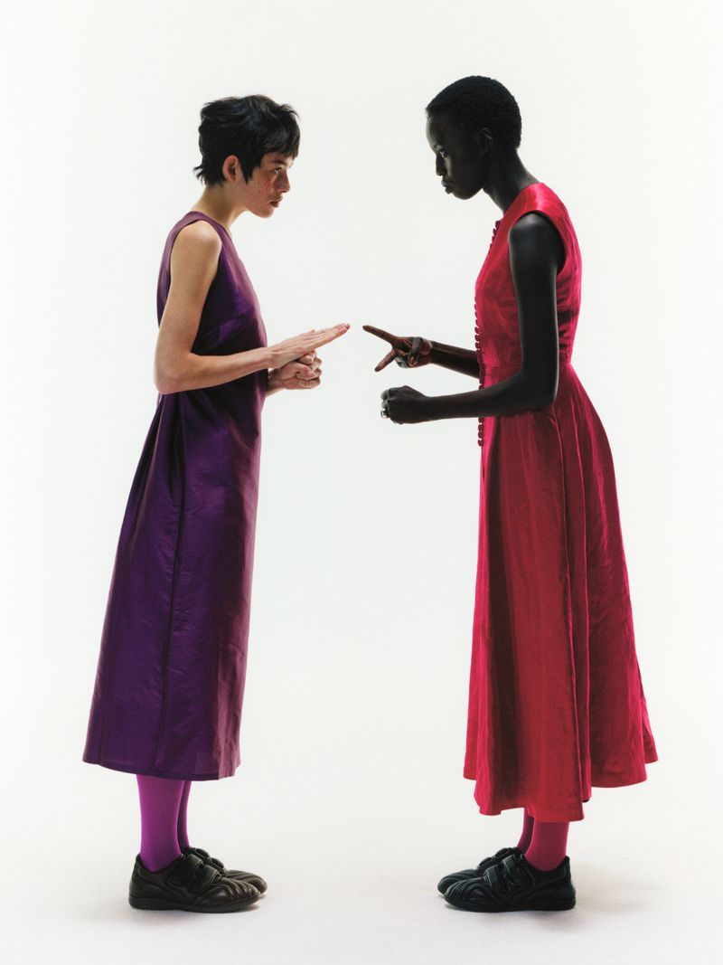 two models on a white background playing rock paper scissors