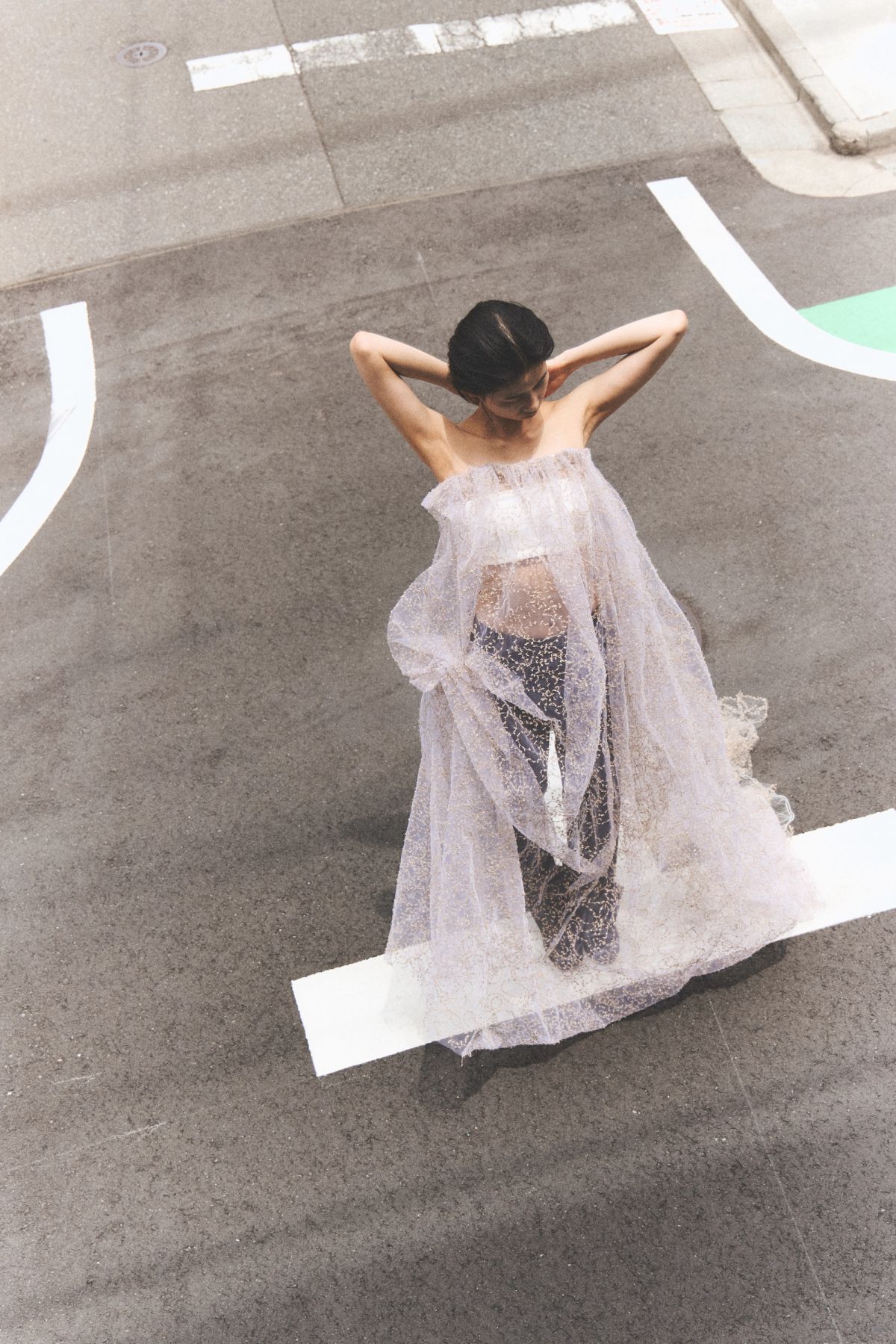 model looks down at her feet with hands behind her head