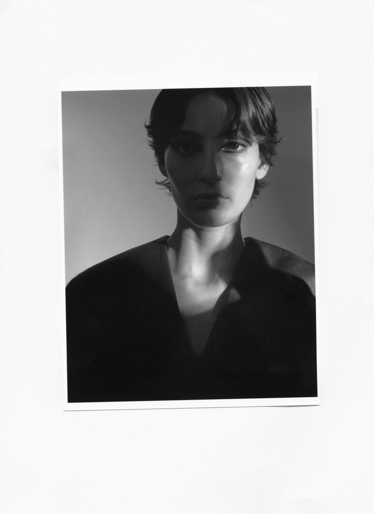 black and white image of model in shadow stairs directly at the camera