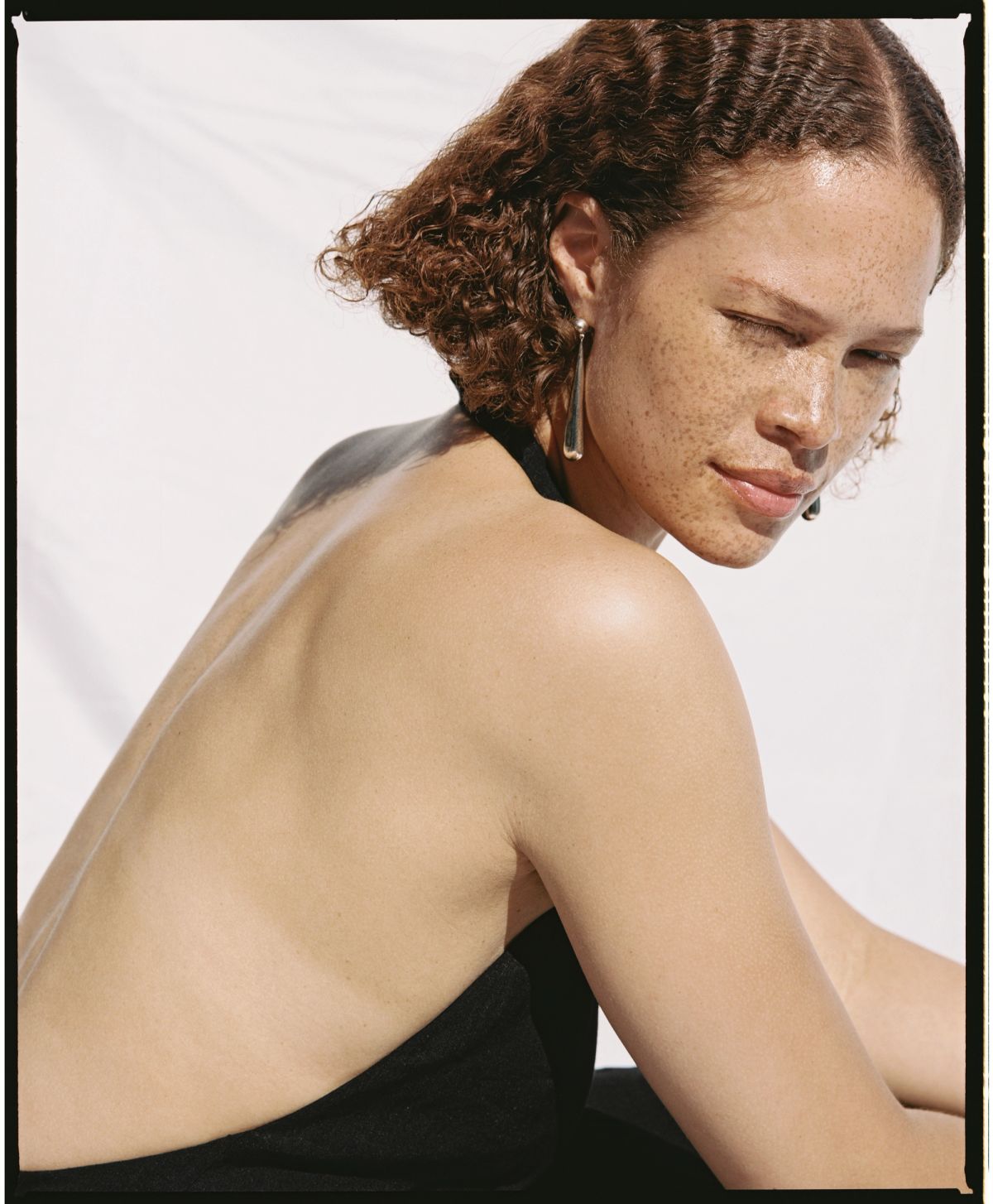 women stares into camera as the sun bathes her skin