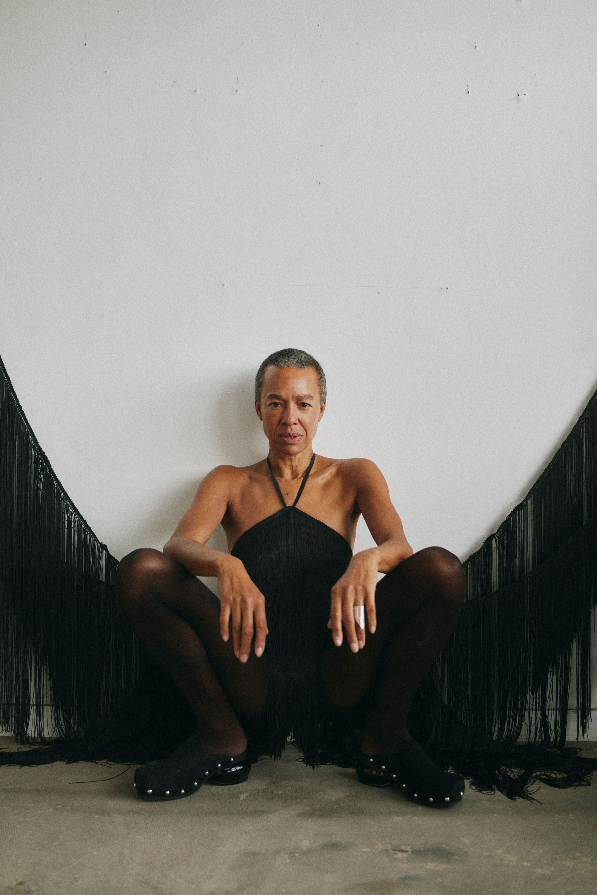 women crouching wearing a black dress