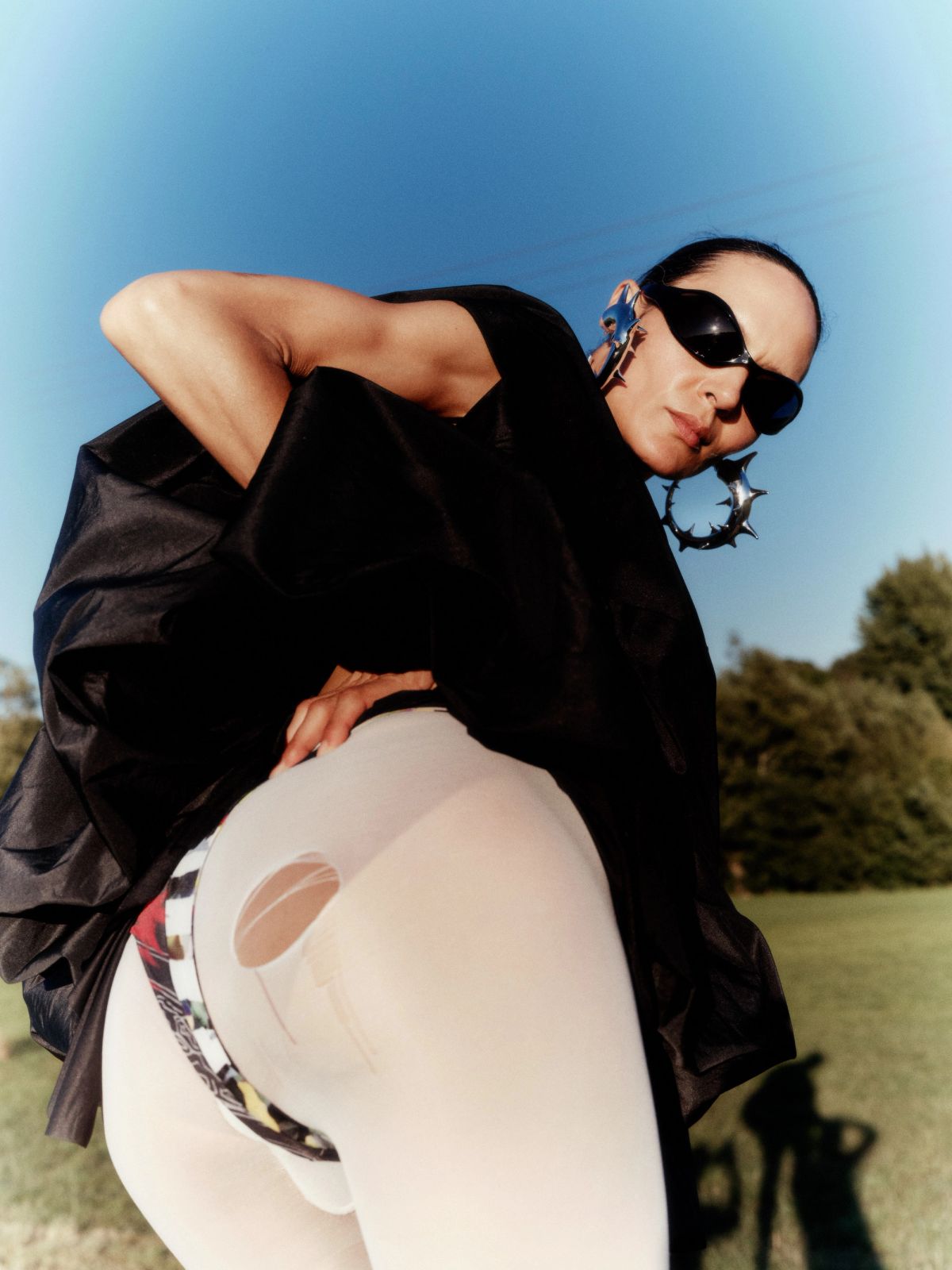 women in filed wearing black lifting up her dress