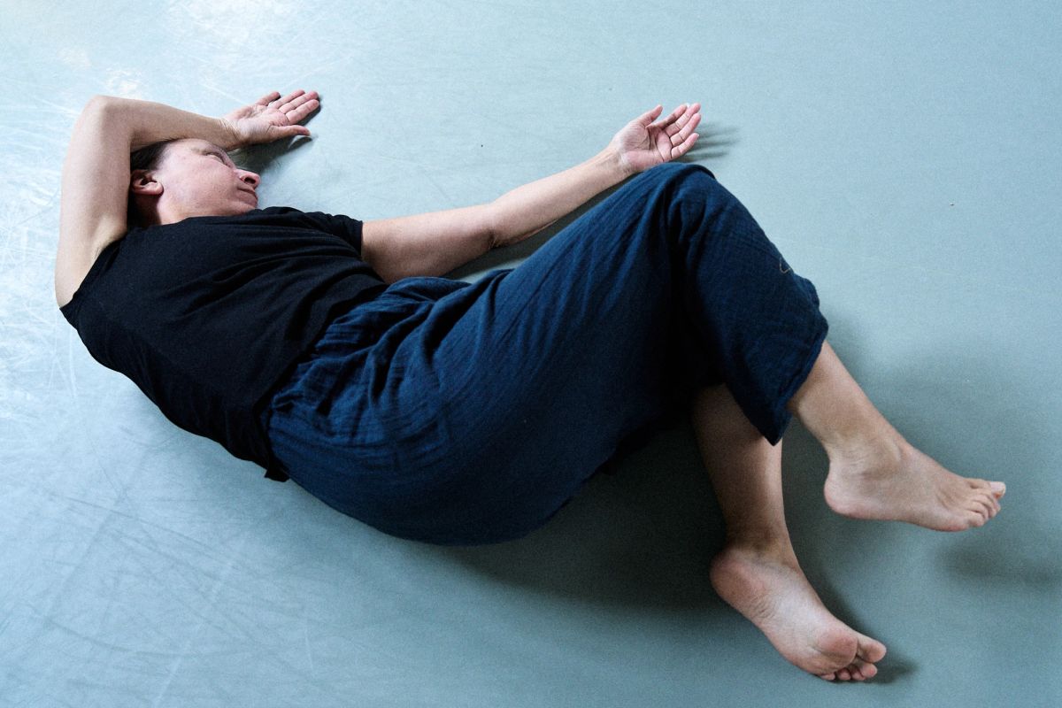 women stretching on the floor of a dance studio wearing black and blue