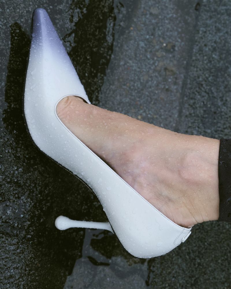 A wet high heeled pump that fades from lilac to white on a models foot