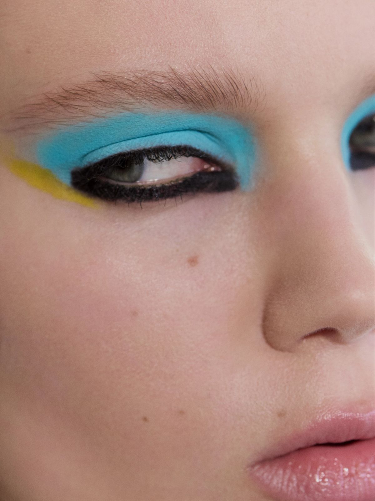 Close up with blue and yellow eyeshaddow, heavy black liner