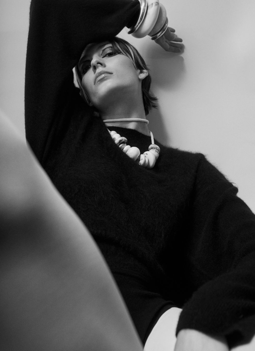 model wearing black jumper necklace and bangles on white background