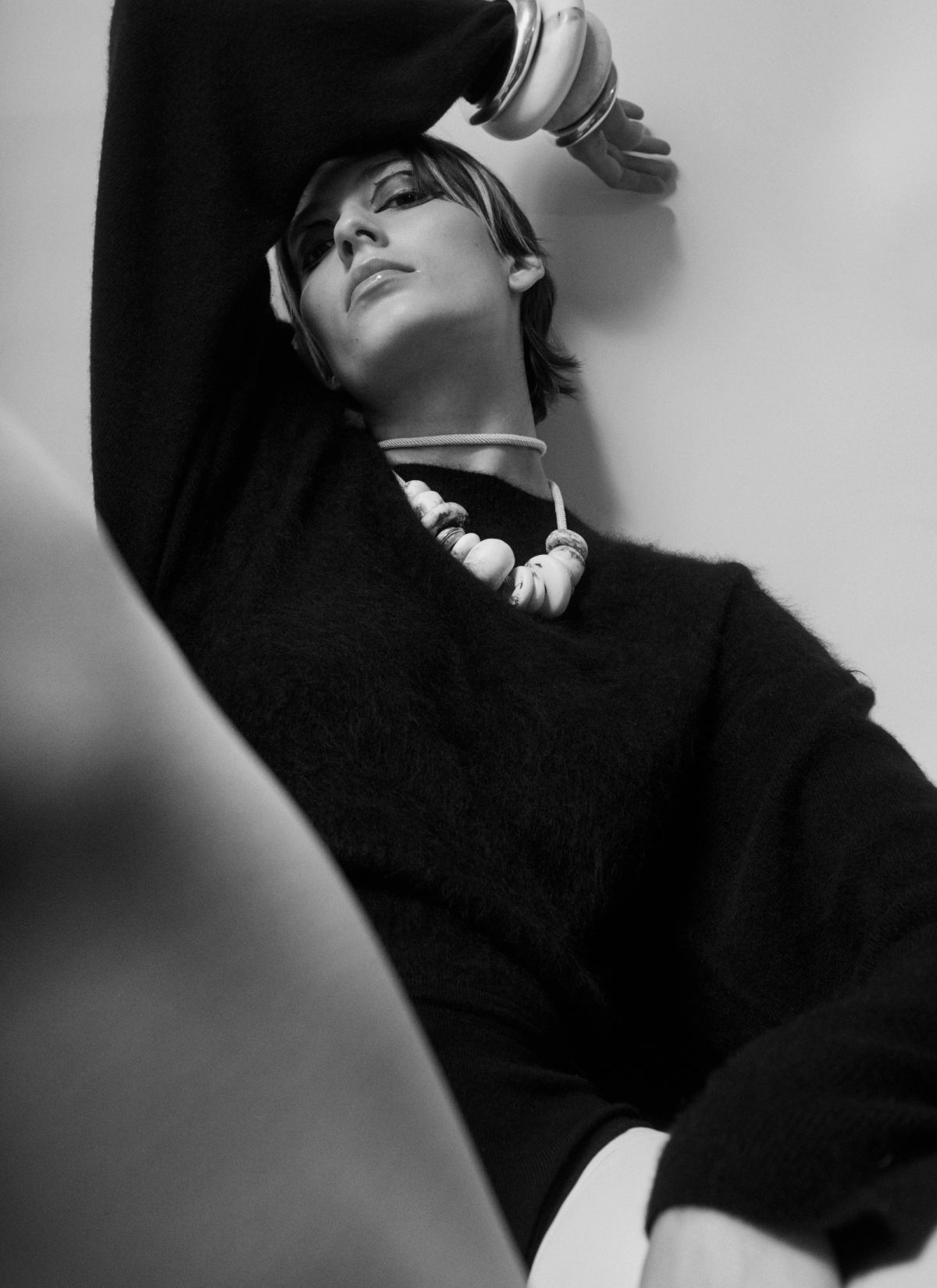 model wearing black jumper necklace and bangles on white background