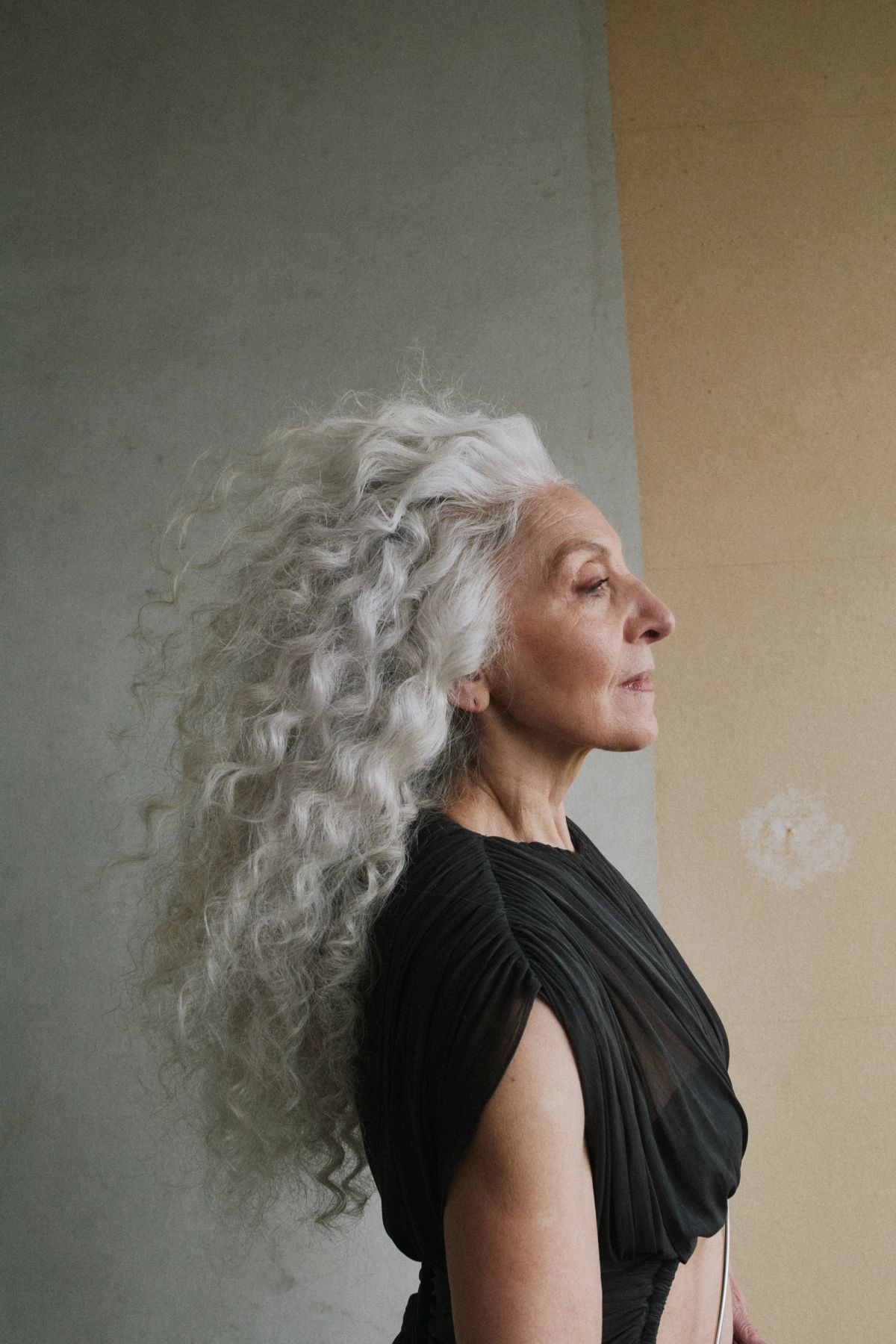 portait of a woman with wavy white hair wearing a black dress 