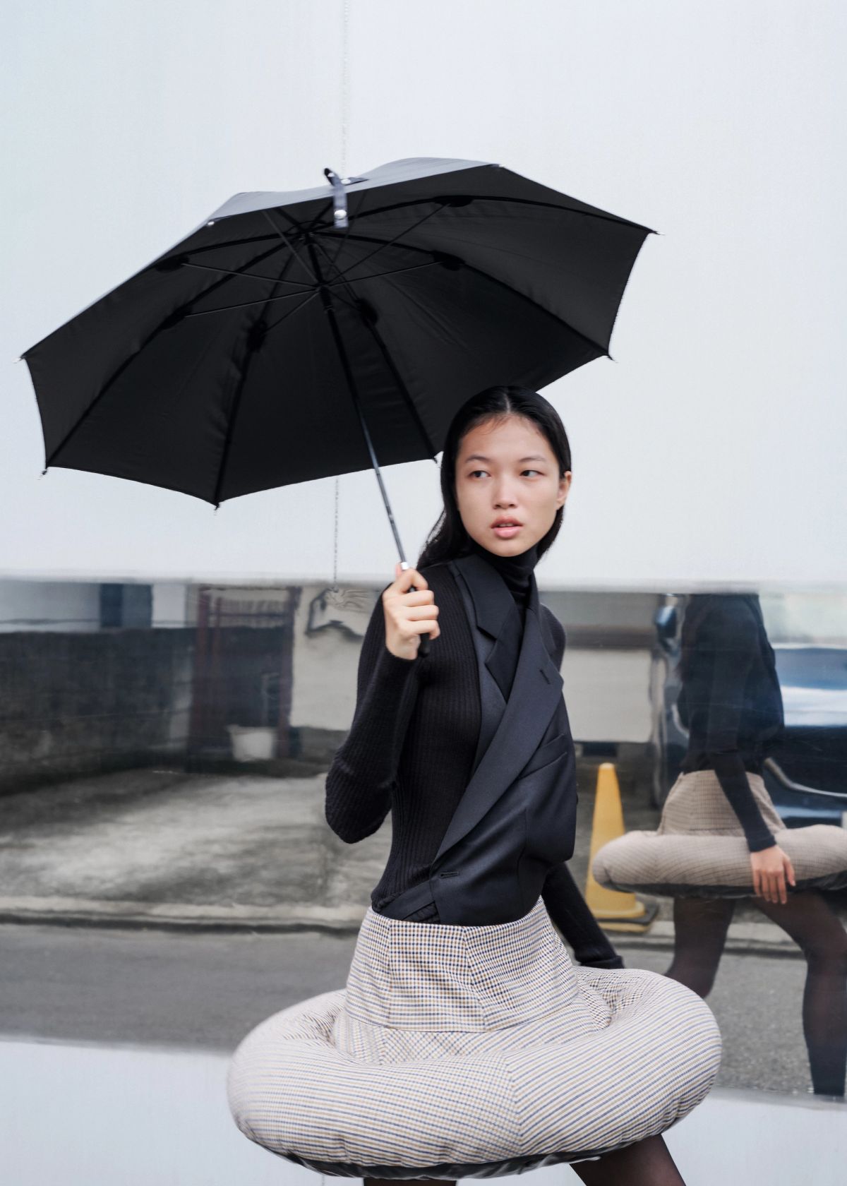 model holding an umbrella with a mirror behind them