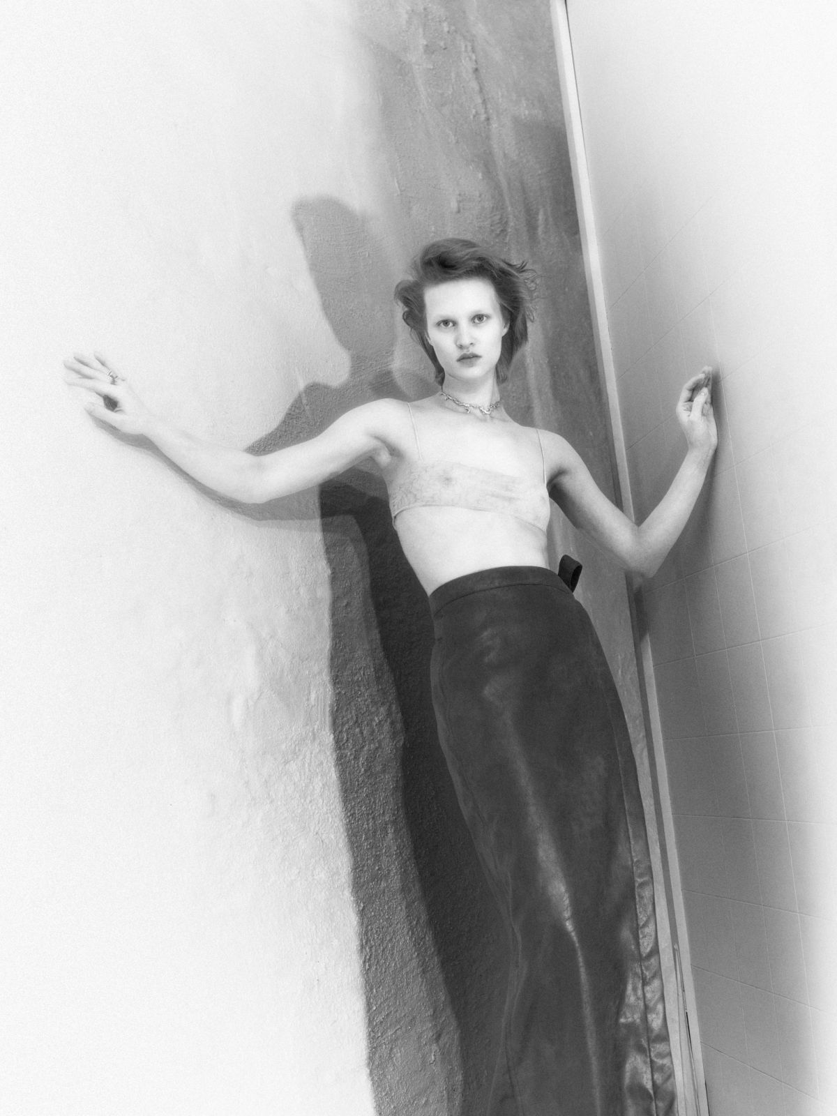 women in a corner studio with column skirt and transparent bra