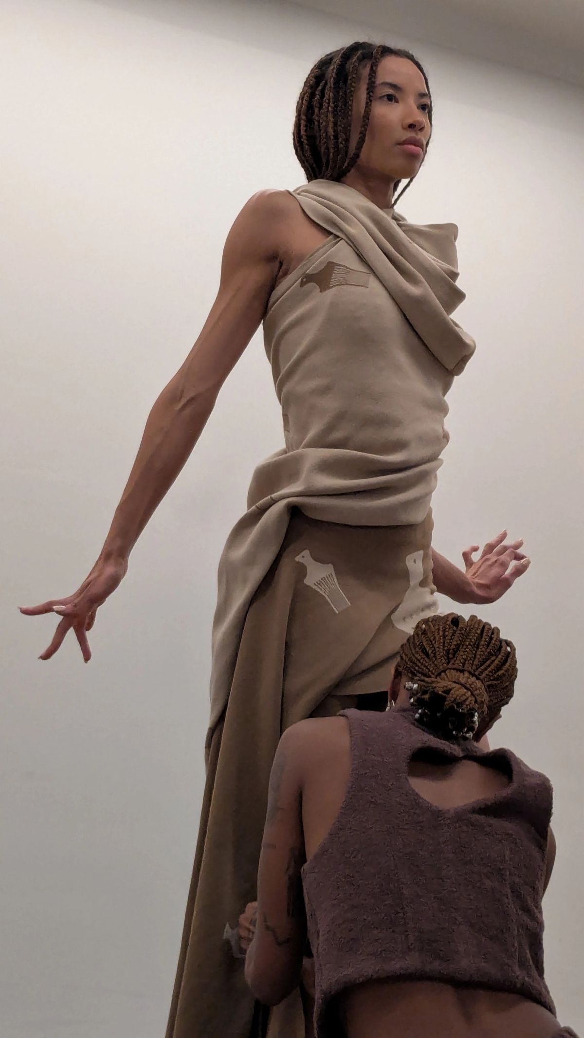 One woman draping clothing on to another woman