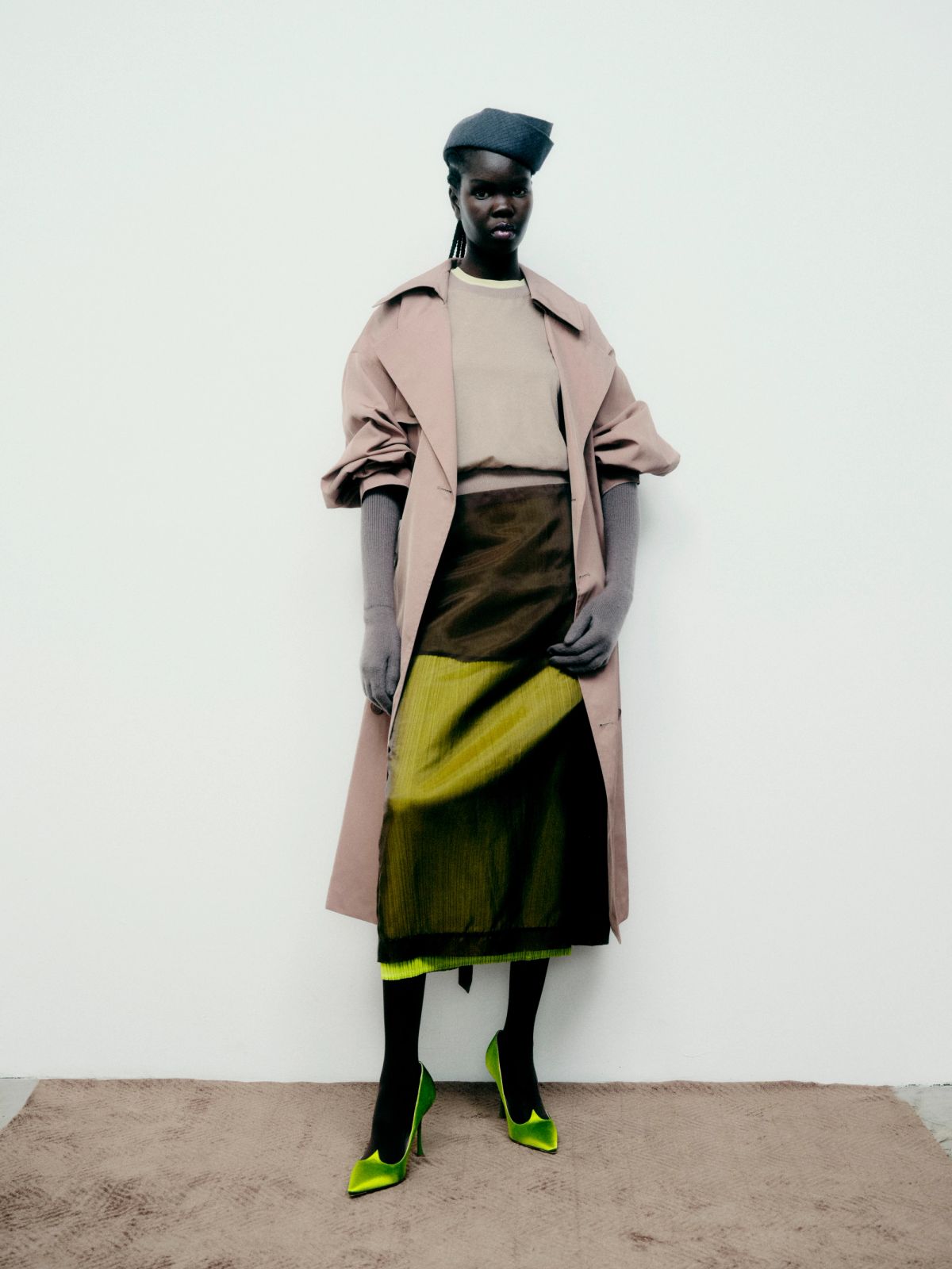 Model standing against the wall in a studio wearing winter clothing