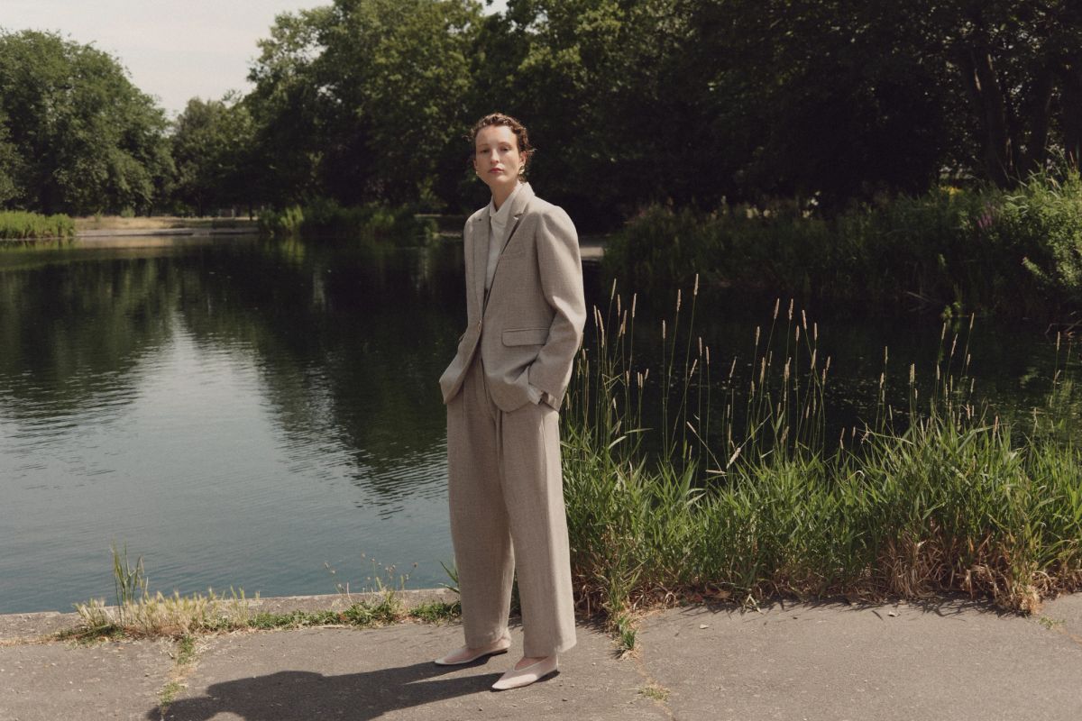Woman standing by water in a suit