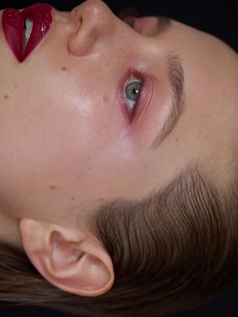 extreme close up model sideways with burgundy lips and soft red eyeshadow