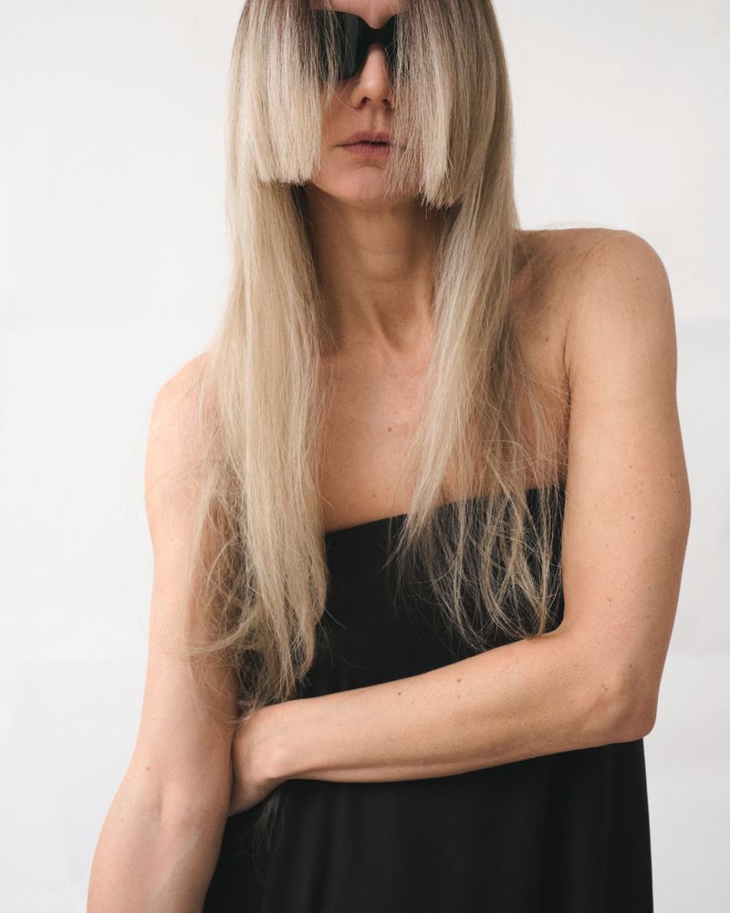 women wearing a black bandeau dress and sunglasses with blonde hair