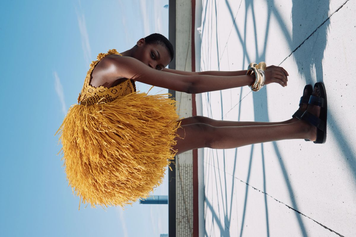Women on a rooftop wearing yellow bending over