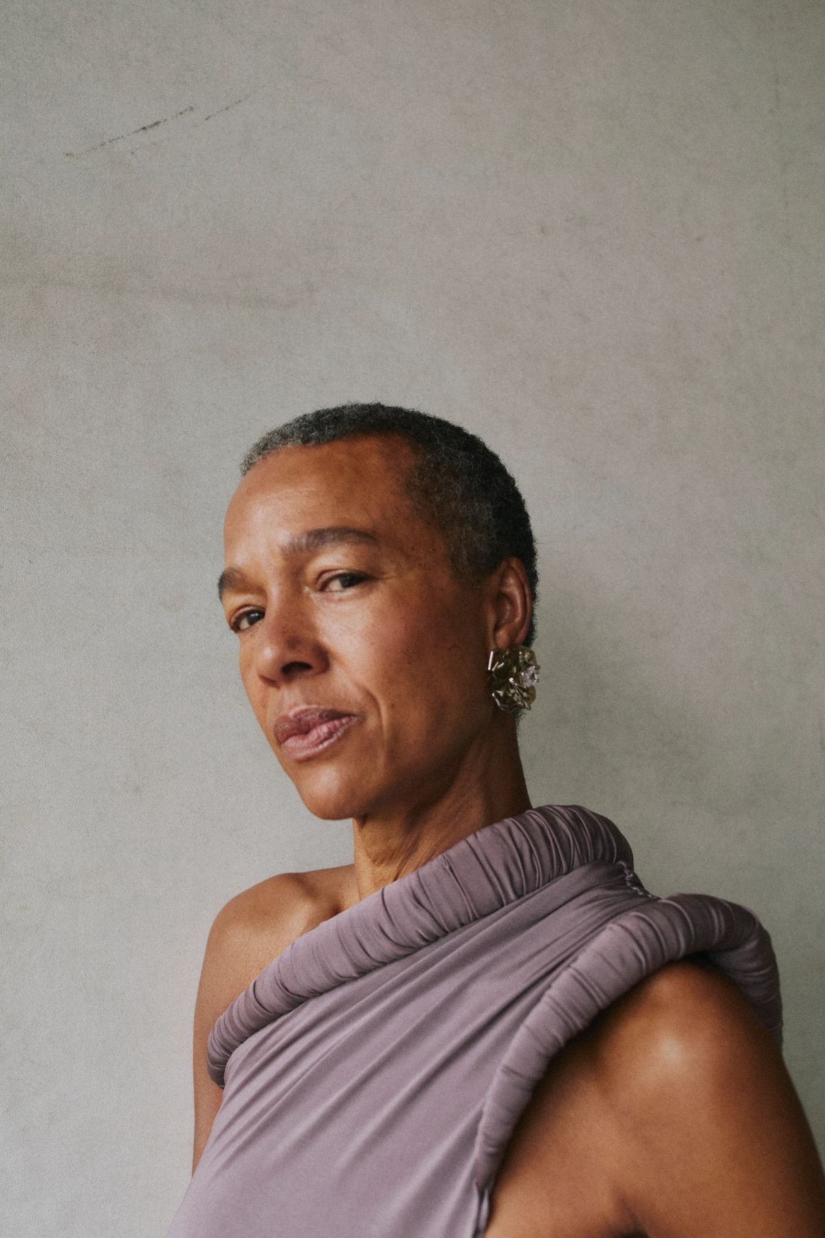 Women stairs unapologetically into the camera with a shaved head