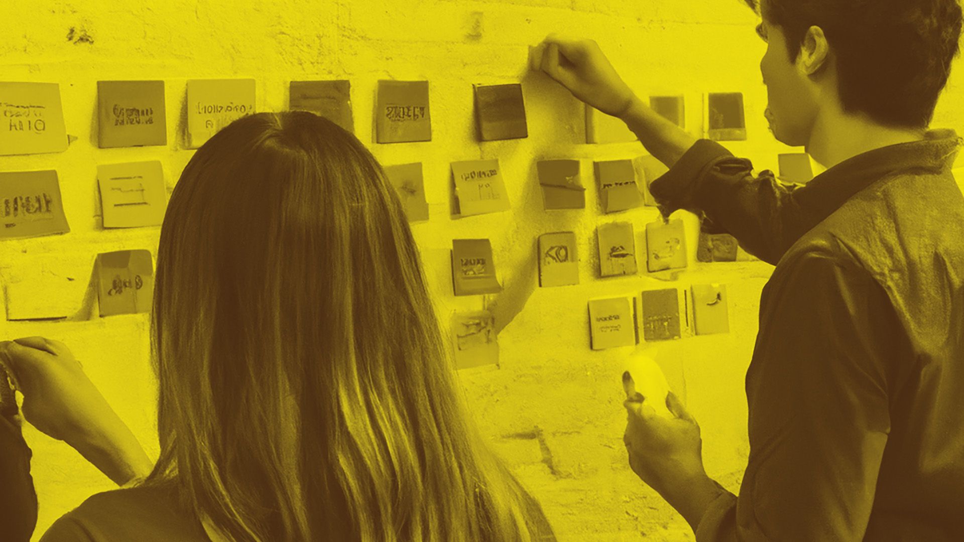 photograph of people in a workshop meeting with post-it notes and writing on the wall