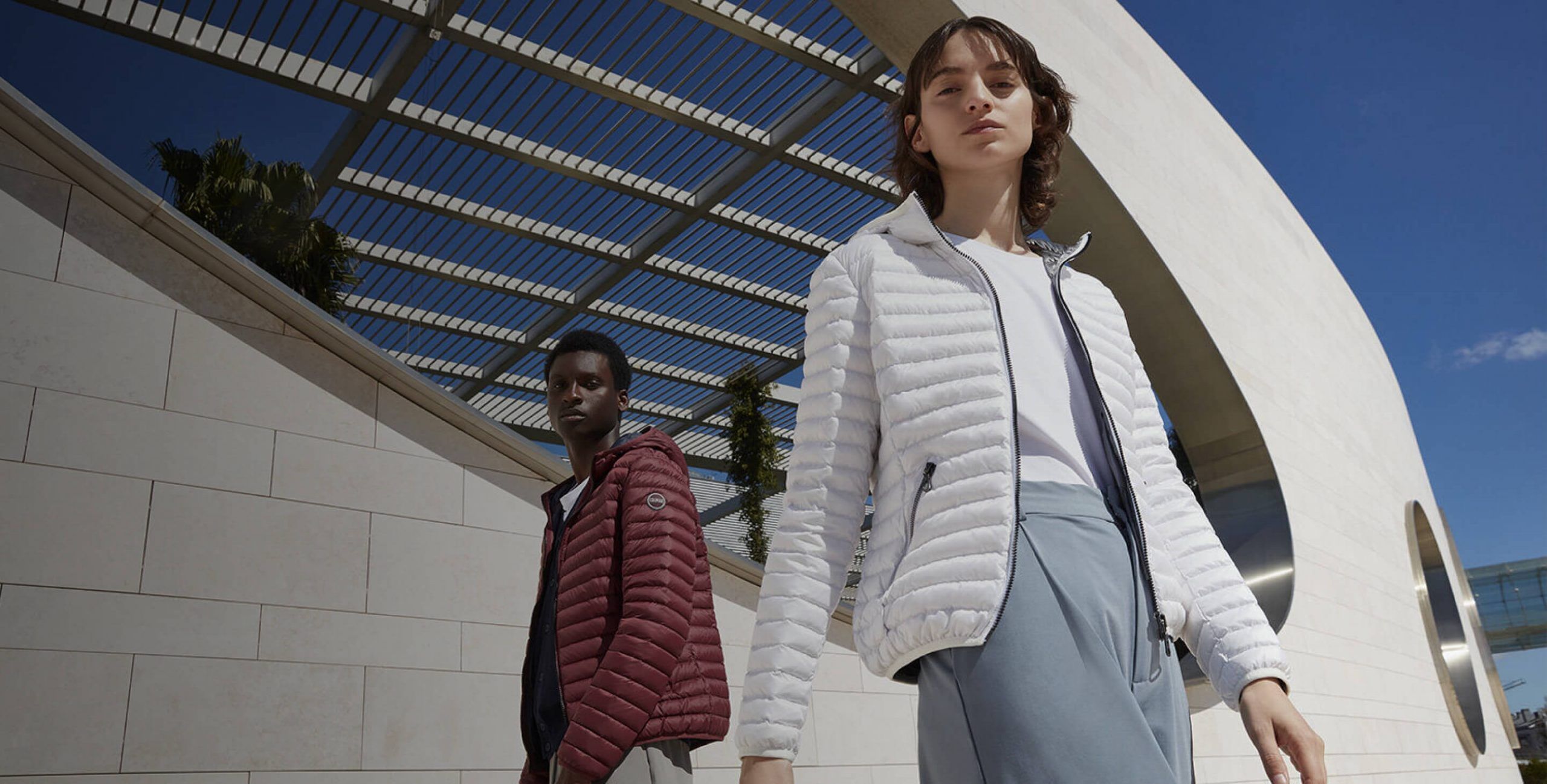 girl in the foreground and boy in the background in front of a building