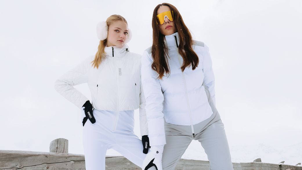 Two women in white ski suits