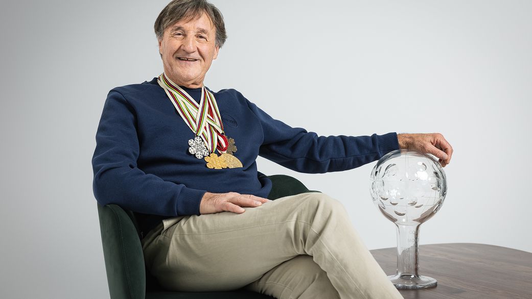 Piero Gros seduto con premio e medaglie