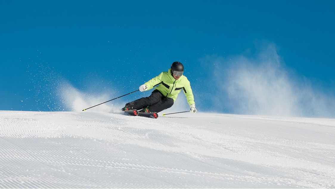 Uomo con tuta da sci mentre scia