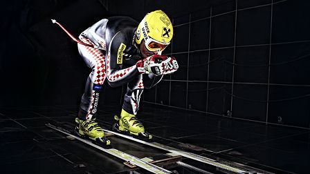 Uomo in tuta da sci che sta sciando in galleria
