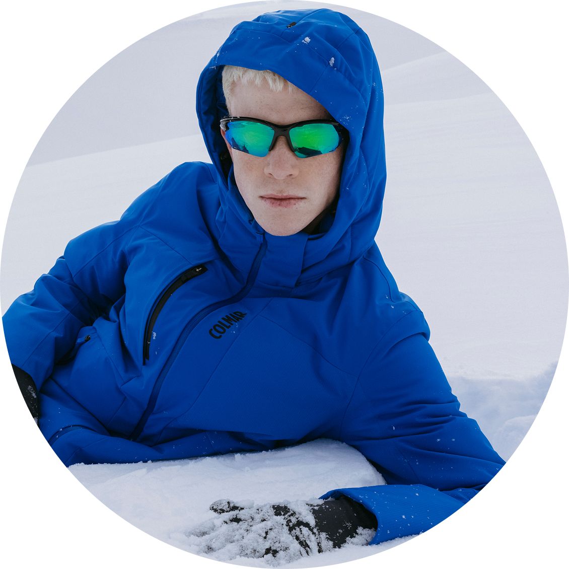 Uomo sdraiato sulla neve con giacca blu