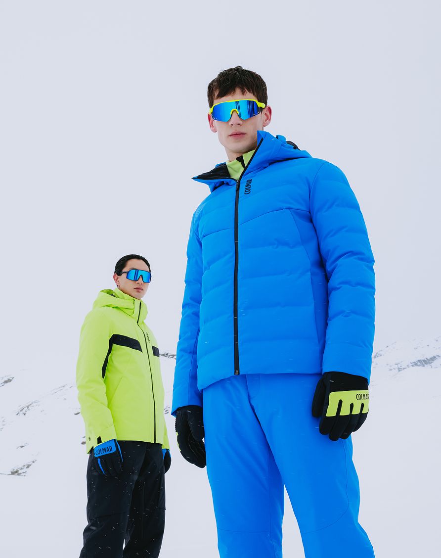 Uomini sulla neve con giacca azzurra e verde fluo