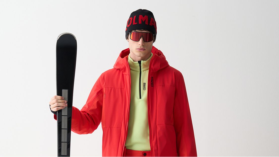 Uomo con giacca rossa e sci