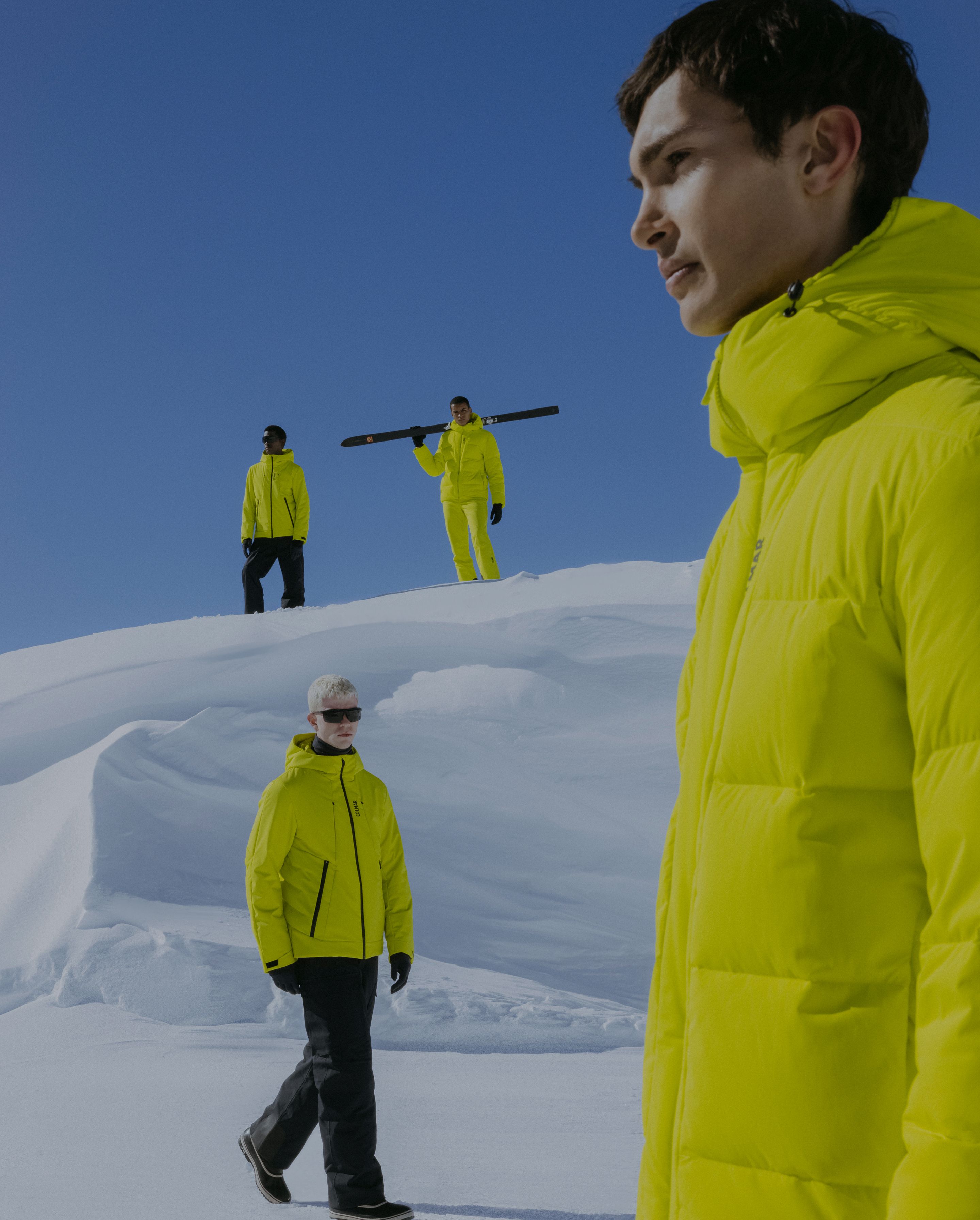 Shooting quattro uomini con tuta giallo fluo sulla neve