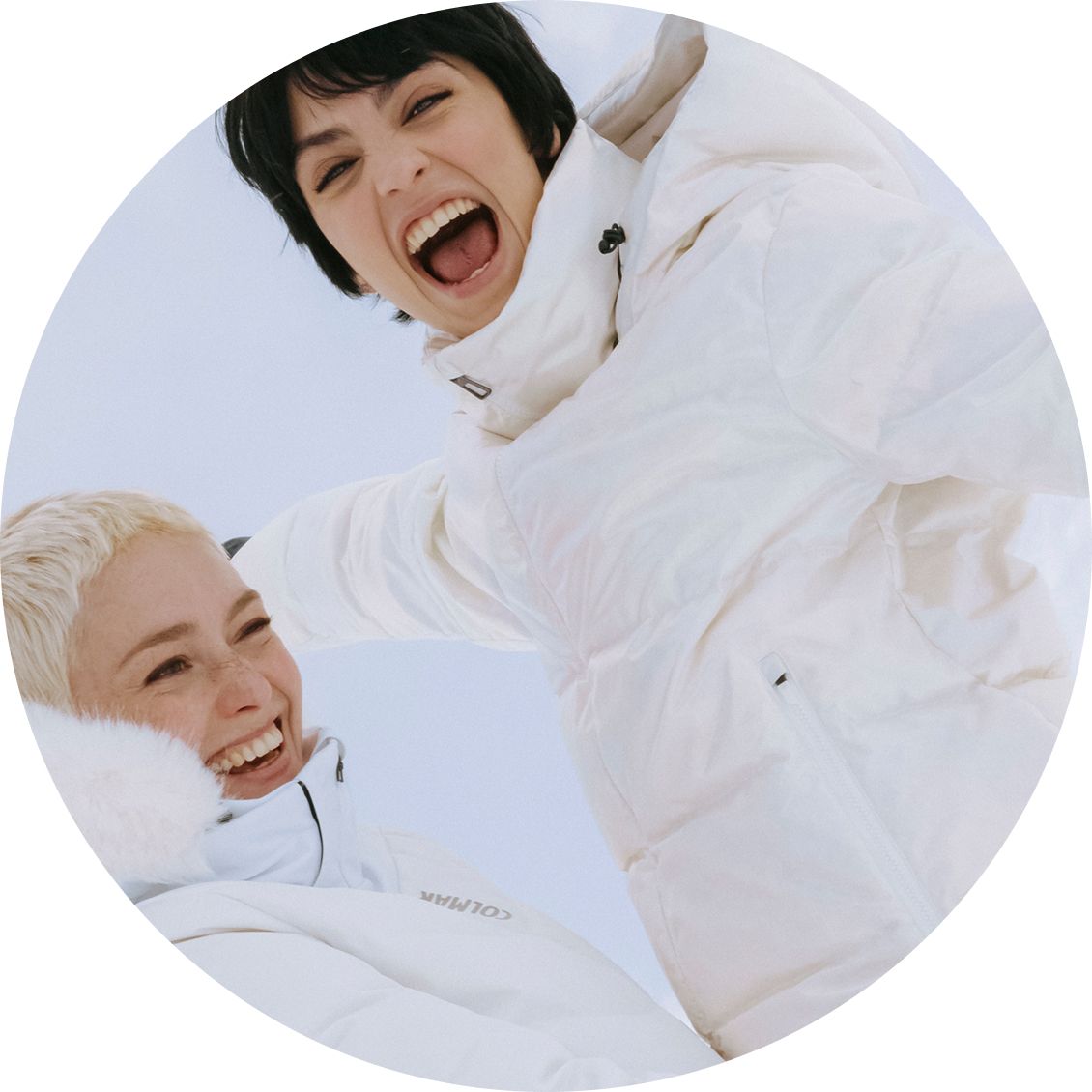 Due ragazze felici con tuta da sci bianca