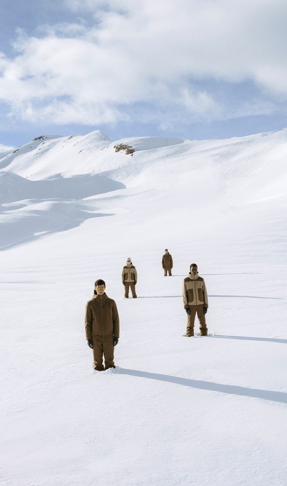 Quattro uomini con tuta sulla neve