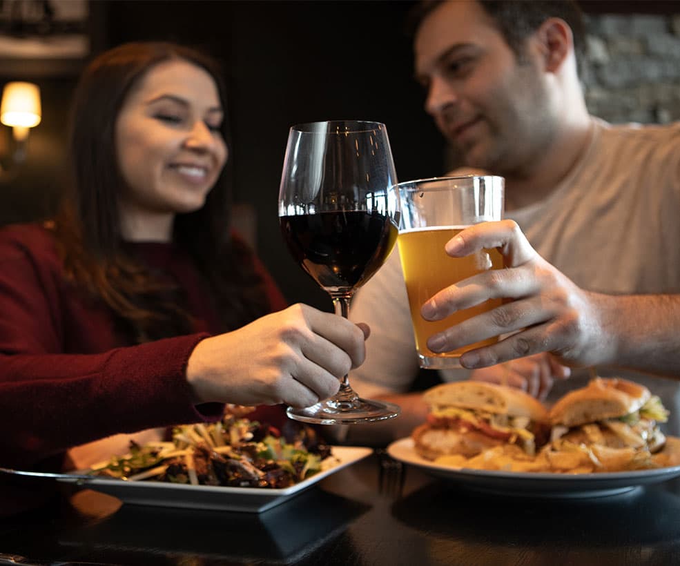 A couple having wine and beer with dinner.