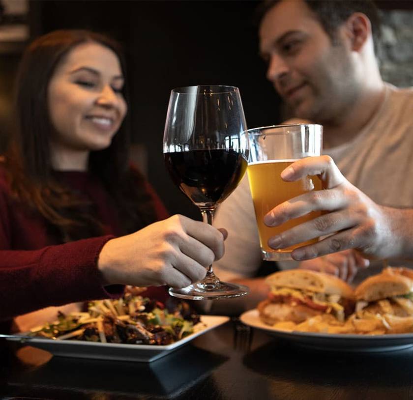 A couple having wine and beer with dinner.