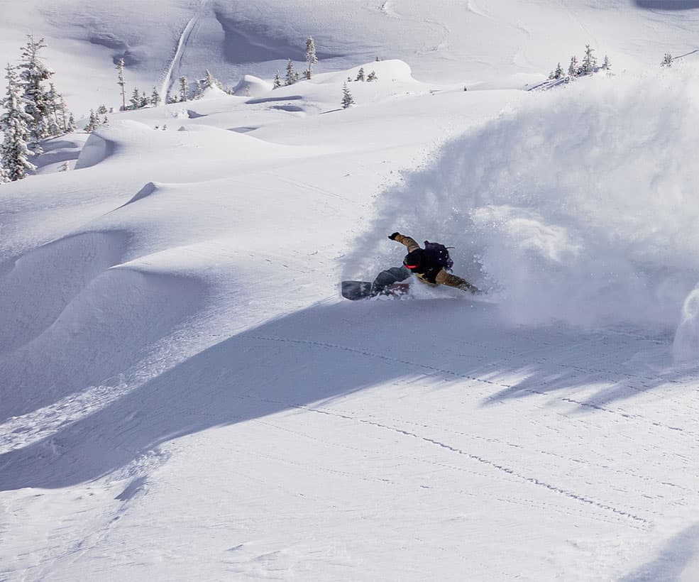 A snowboarder shredding on a mountain slope.